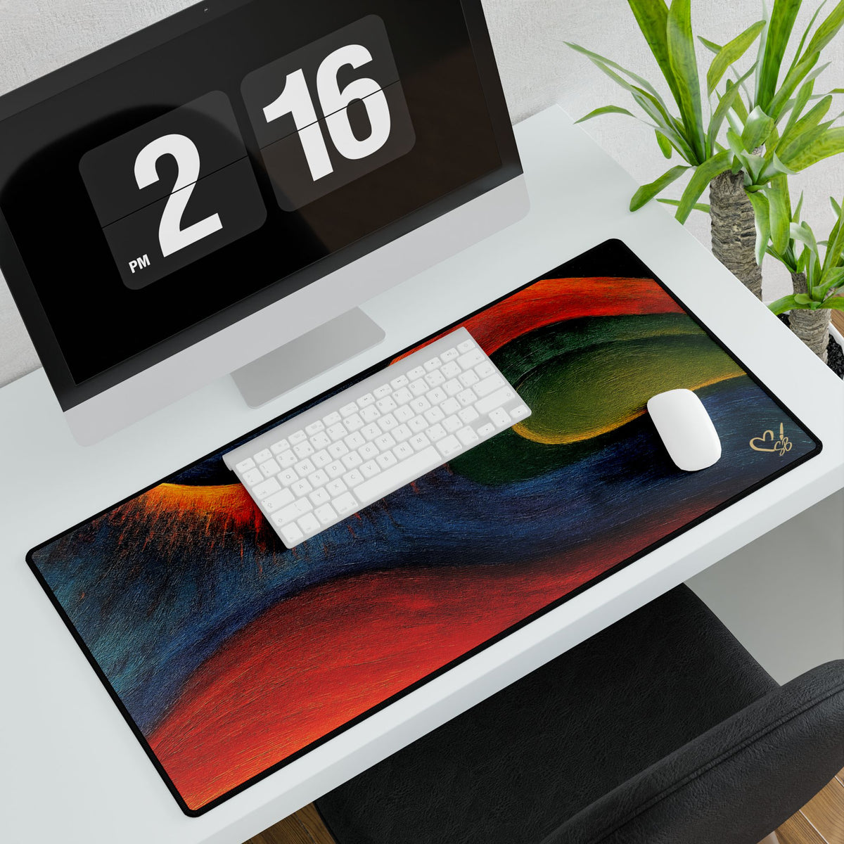 Abstract desk mat beneath a white keyboard and mouse, with sweeping red, blue and green artwork.