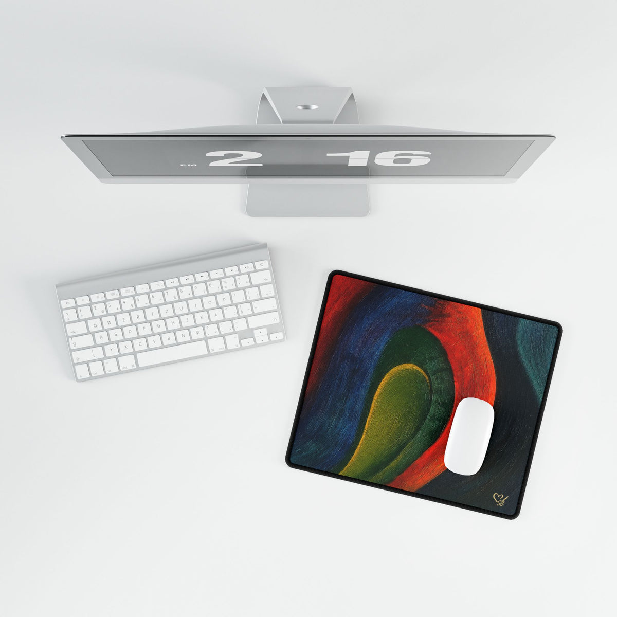 Overhead view of the compact abstract desk mat and white mouse beside a keyboard.
